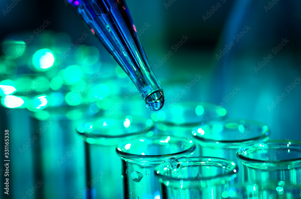 Wall mural pipette adding fluid to one of several test tubes, medical abstract background.