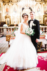 Naklejka premium Married couple posing in a church after ceremony