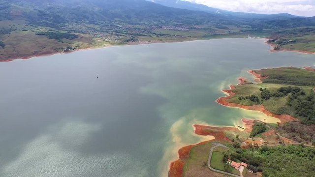 Drone view of a tropical rainforest mountain with clouds and mist. Huge Calima lake from above. Aerial 4K video. Colombia, South America