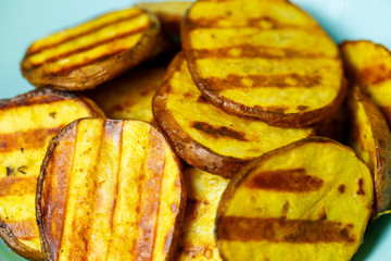 grilled potatoes until golden brown in a blue plate on a yellow background