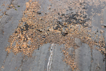 many small stones of different colors and sizes on top of a large rock