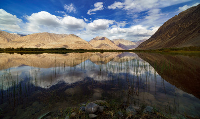 Reflections of the mountains in a natural pond, Nubra Valley , Jammu and Kashmir, India