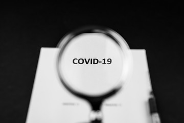 Pandemia COVID-19, napis powiększony przez lupe, strzykawka, stetoskop na ciemnym tle - obrazy, fototapety, plakaty