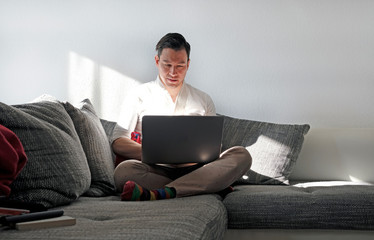 Man working from home with a laptop in the living room
