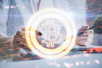 Cryptocurrency hologram, bitcoin, ico theme over hands taking notes background. Concept of blockchain. Multi exposure