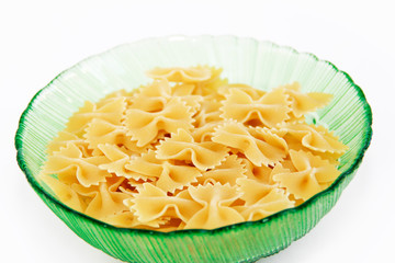 natural dry yellow pasta butterflies farfalle in a green plate