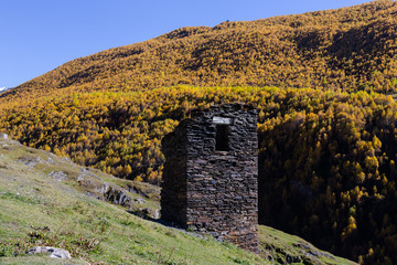 Old stone houses and fences of the village of Ushguli in a beautiful autumn landscape with white clouds in Svaneti. Georgia