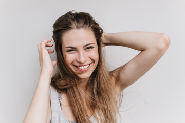 Fototapeta premium Joyful european woman laughing on white backgorund during photoshoot. Indoor photo of romantic girl expressing happiness.