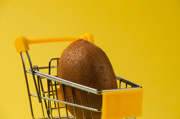 Kiwi on a yellow background in a grocery cart, side view close-up