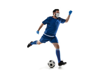 Obraz premium Beat the disease. Male football, soccer player in protective mask. Prevention against pneumonia. Still active while quarantine. Chinese coronavirus treatment. Healthcare, medicine, sport concept.