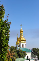 Fototapeta na wymiar View of the temples of Kiev-Pechersk Lavra on a beautiful sunny autumn day. Gold domes, orthodox crosses. UNESCO World Heritage Site