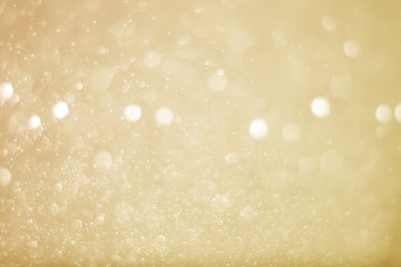 Abstract bokeh sparkle on yellow and gold background
