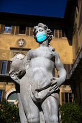 Naklejka premium Italian statue wearing a medical chirurgical mask against virus and disease