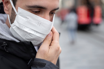 The adult man wanders the streets of Istanbul with a mask to prevent infectious diseases.