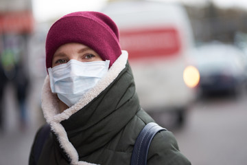 Caucasian woman wearing medical mask outdoors during outbreak