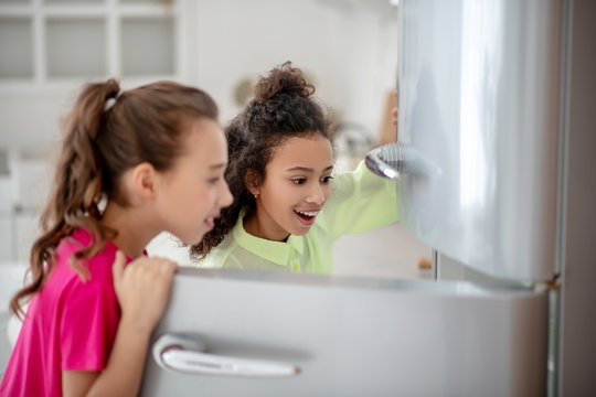 Two Girls Opening The Fridge Looking Excited