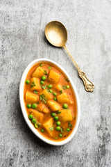 Aloo Curry Sabzi made using boiled potato with green peas. Served in a bowl or karahi, selective focus