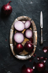 Obraz premium Top view red onions on a plate and knife