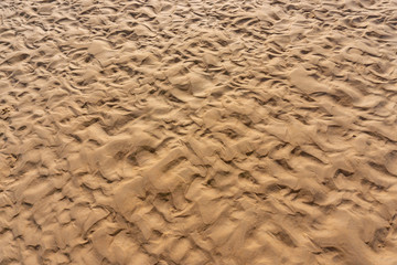 Top view image of brown wet sand  wave textured on the beach