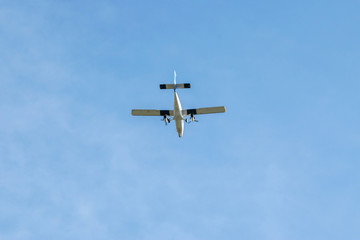 Light aircraft flying over head against a blue sky