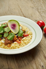 Juicy and unusual Israeli chicken steak (Pargiyot) with a side dish of polenta, corn porridge. Grilled chicken. Wooden background