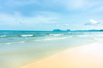 Fototapeta na wymiar Clean white beach golden brown sand and small wave from blue sea under clear blue sky in a sunny day
