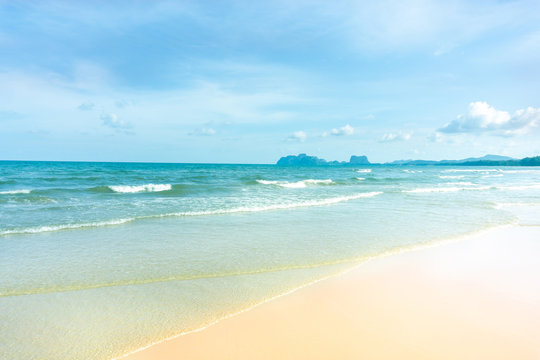 Clean white beach golden brown sand and small wave from blue sea under clear blue sky in a sunny day