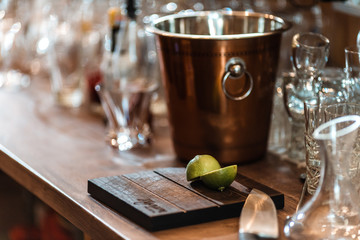 Halved fresh lime on a cutting board with a silver bucket on the background