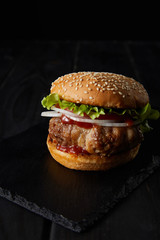 tasty burger on wooden surface isolated on black