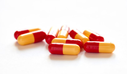 on spilling pills out of glass on white background