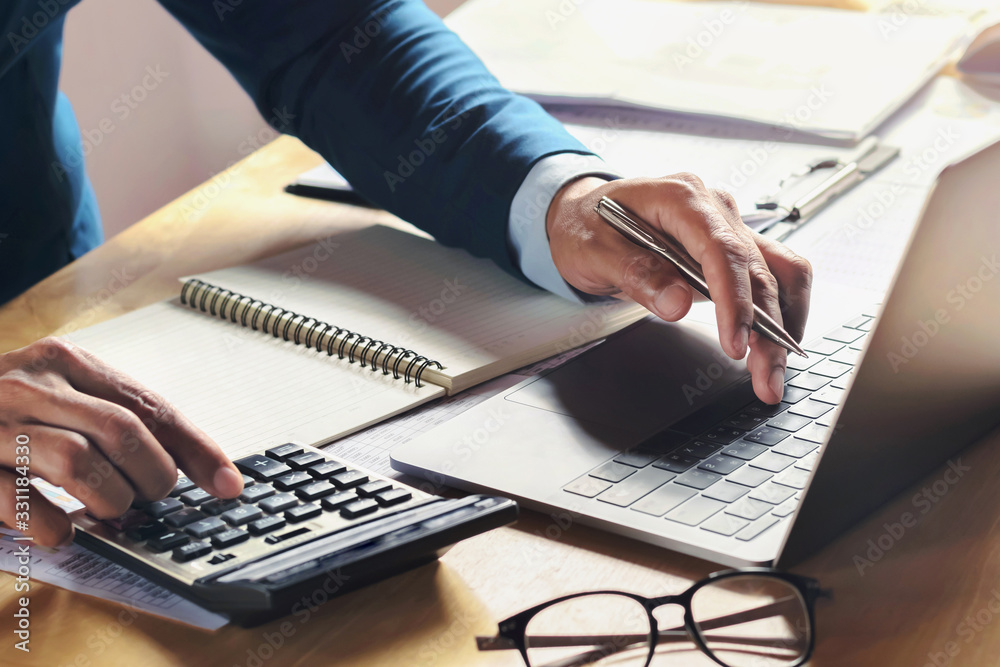 Poster businessman working on desk with using calculator and computer in office. concept accounting finance