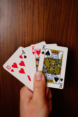 Poker cards with assorted combinations in man hand close up and isolated background