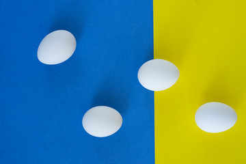 White eggs on blue and yellow background