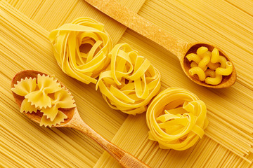Geometrical arrangement of raw spaghetti with tagliatelle farfalle and cellentani