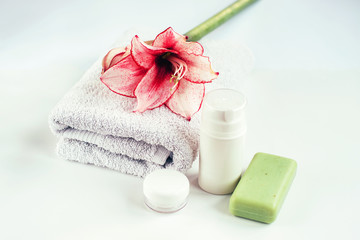 Natural cosmetics, a towel and handmade soap on white table.