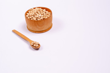 Dry chickpeas for vegans in a wooden spoon and bowl on a white background, copy space, place for text.