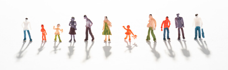 Naklejka premium Panoramic shot of people figures on white surface with shadow