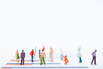 Close up view of plastic people figures on surface with graphs isolated on white, equality concept