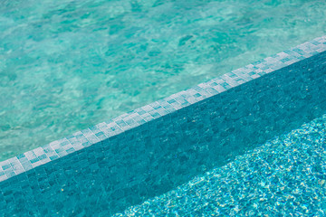 Sunny swimming pool detail on the bright summer day. Summer vacation or holiday concept