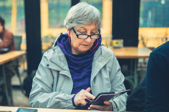 Mature woman using smartphone in cafe