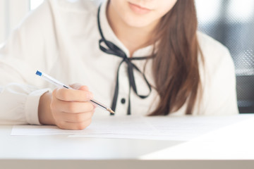 Filling out documents for obtaining a visa of a foreign state. Hands hold a pen over paper