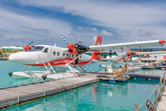 Male, Maldives – May 10, 2019: TMA - Trans Maldivian Airways Twin Otter seaplanes at Male airport (MLE) in the Maldives. Seaplane parking next to floating wooden jetty, Maldives