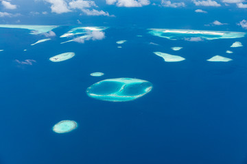 Naklejka na ściany i meble Maldives aerial view with atolls and islands. Amazing view from seaplane or drone, luxury vacation travel scenery