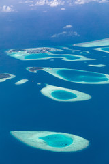 Maldives aerial view with atolls and islands. Amazing view from seaplane or drone, luxury vacation travel scenery