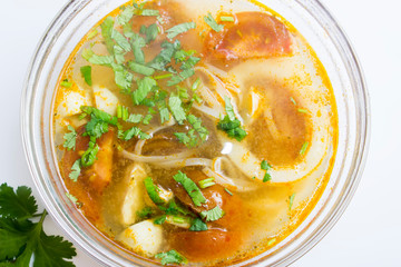 Tom yum (Tom Yam) soup with chicken and squid on top on white background