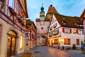 Fototapeta na wymiar Decorated and illuminated Christmas street with gate and tower Markusturm in medieval Old Town of Rothenburg ob der Tauber, Bavaria, southern Germany