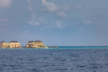 Panorama of Water Villas or bungalows and wooden bridge at Tropical beach in the Maldives at summer day