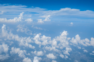 Blue sky with white curly fluffy clouds.