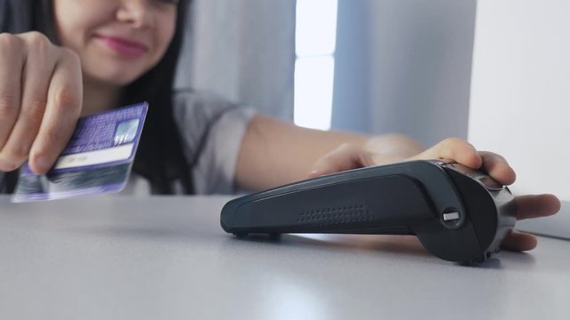 Payment by credit card, purchase and sale of goods and services. Credit card in the store. lifestyle girl pays on the card reader online shopping concept