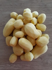 A pile od peeled potatoes on a wooden table